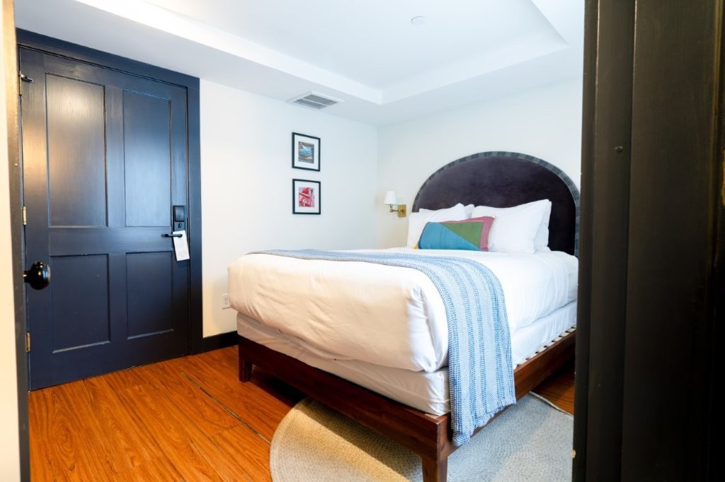 Guest room with bed and orange accent pillow