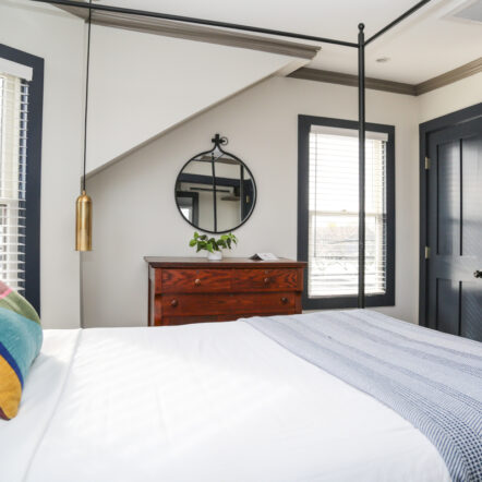 Room with canopy bed and large windows