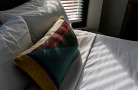Close up of bed with colorful pillow