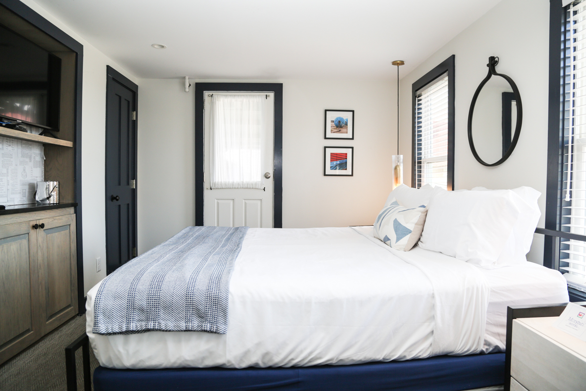 Room with bed and round mirror on the wall