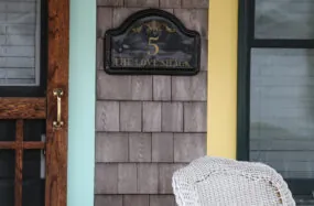 Porch with white chair and wooden walls