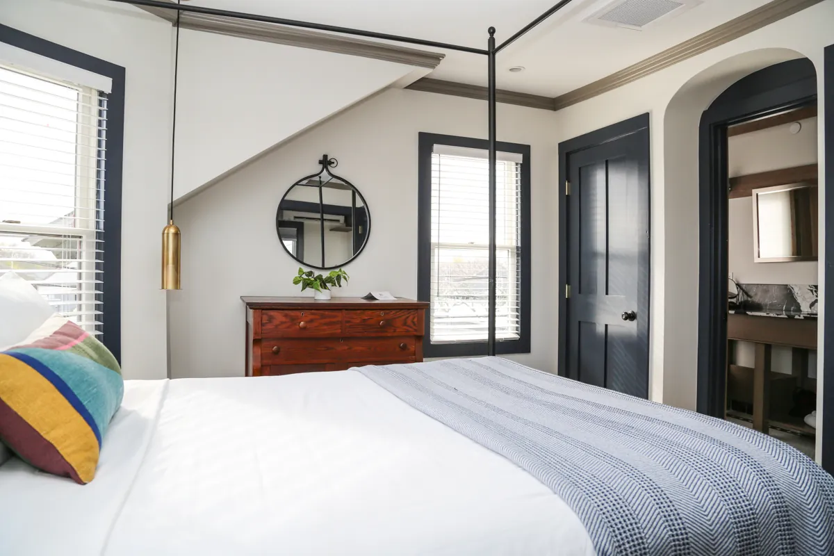 Room with canopy bed and large windows