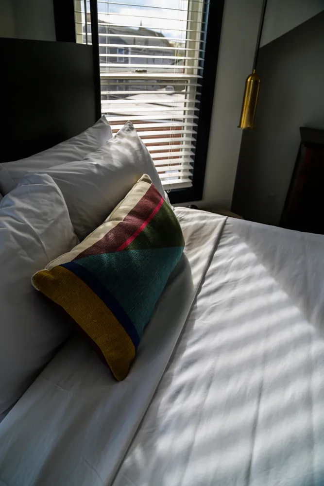 Close up of bed with colorful pillow