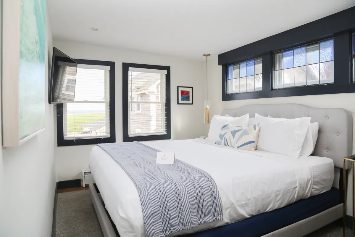 Bed next to wide windows with natural light